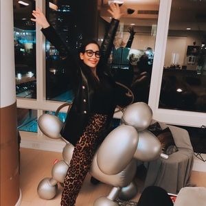 Black leather jacket with high shoulders and gold buttons. Cinched at waist